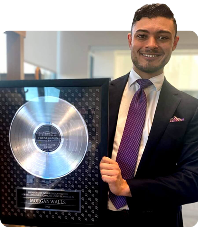 a picture of morgan walls holding up his platinum seven figure president's club award