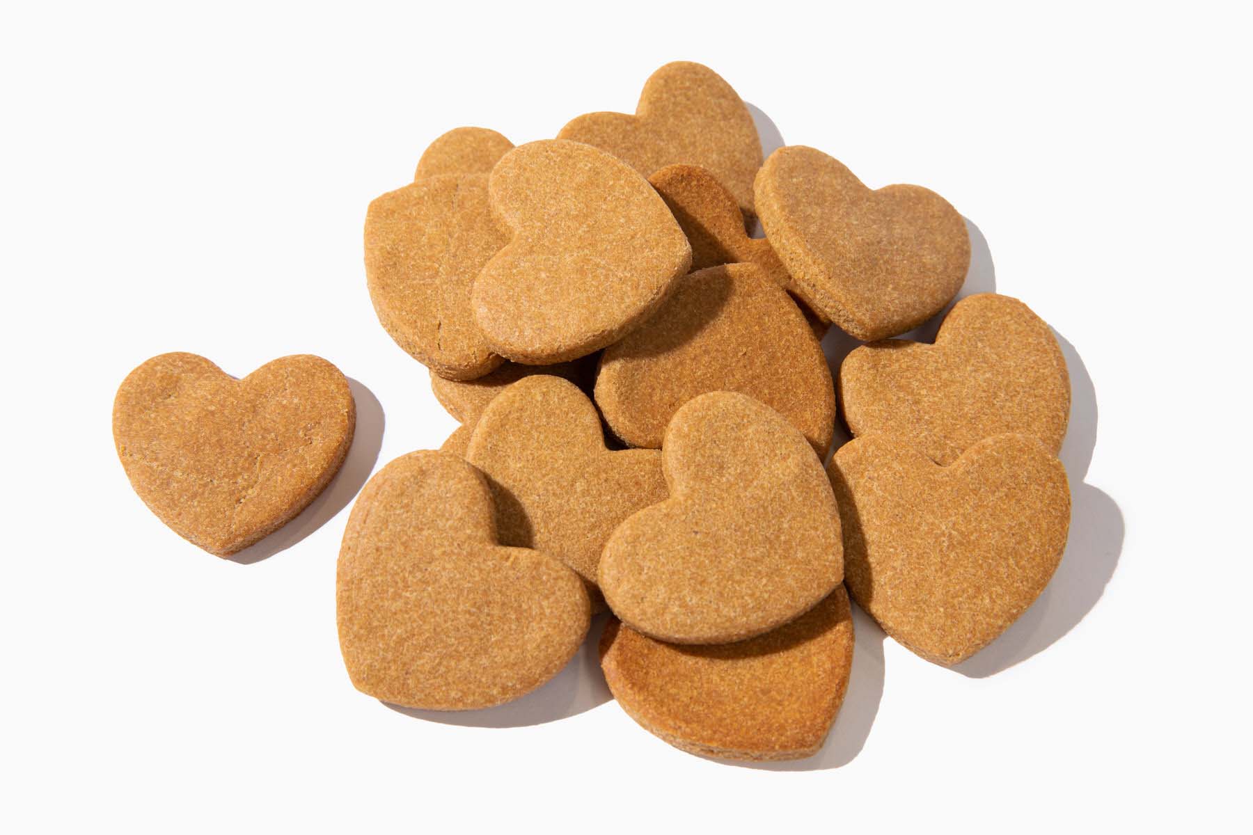 a pile of heart shaped cookies on a white backdrop