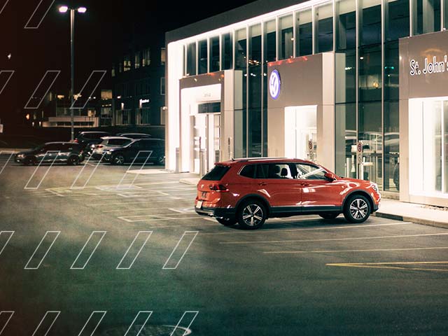 Car parked outside of dealership at night