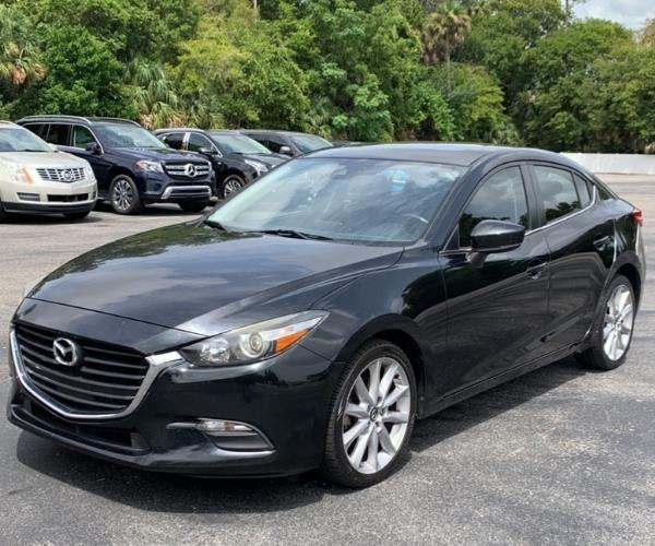 A Black Mazda 3 in a empty dealership parking lot