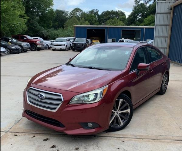 A maroon Subaru Legacy in a parking lot