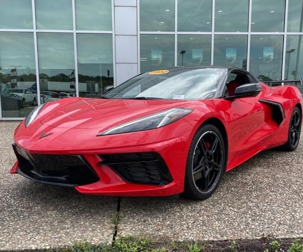 A red 2022 Chevrolet Corvette in front of a dealership