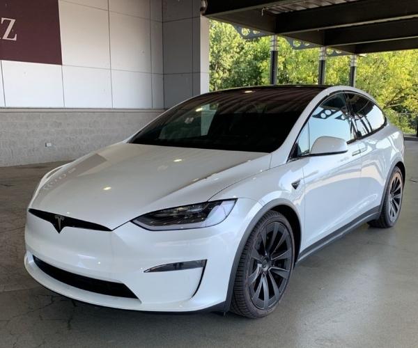 A white 2022 Tesla Model X in a covered parking garage