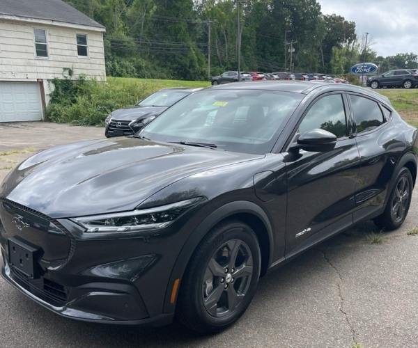 A black 2022 Mustang Mach-E in a dealership parking lot