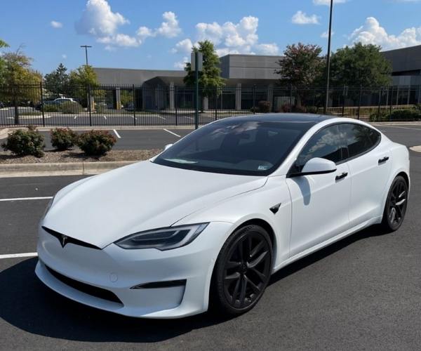 A white 2022 Tesla Model X in an empty office parking lot