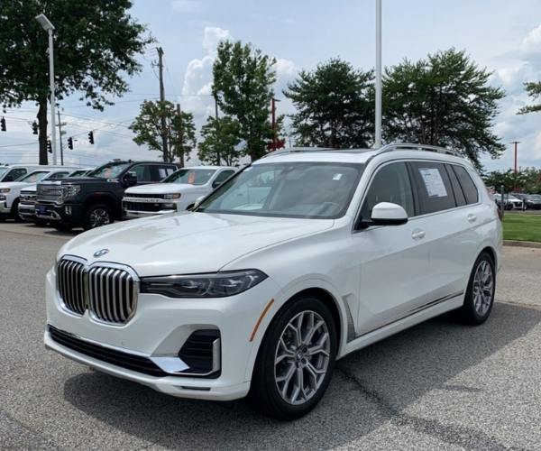 A white 2022 BMW X7 in a full dealership parking lot