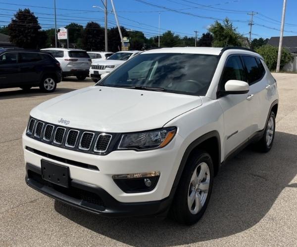 A white 2021 Jeep Compass in a dealer parking lot