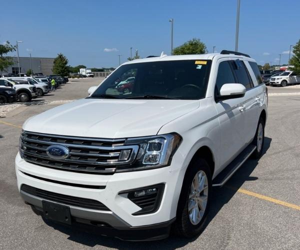 A white 2021 Ford Expedition in a crowded dealer parking lot