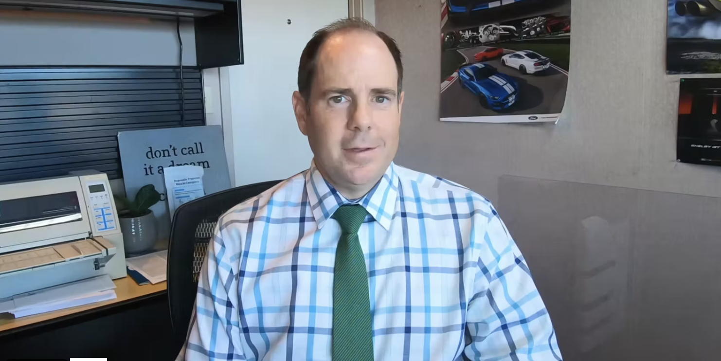 A man at his desk wearing a green tie.