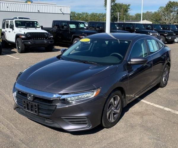 A silver Honda Insight in an empty dealer parking lot
