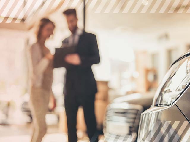 Two employees at a car dealership discussing Finance and Insurance process