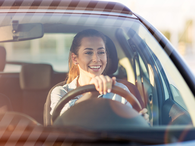 Gen Z driver smiling in her used car