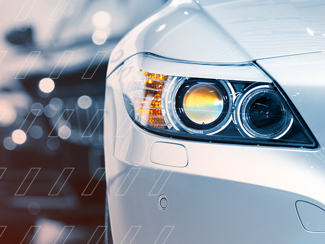 A headlight of a silver luxury car