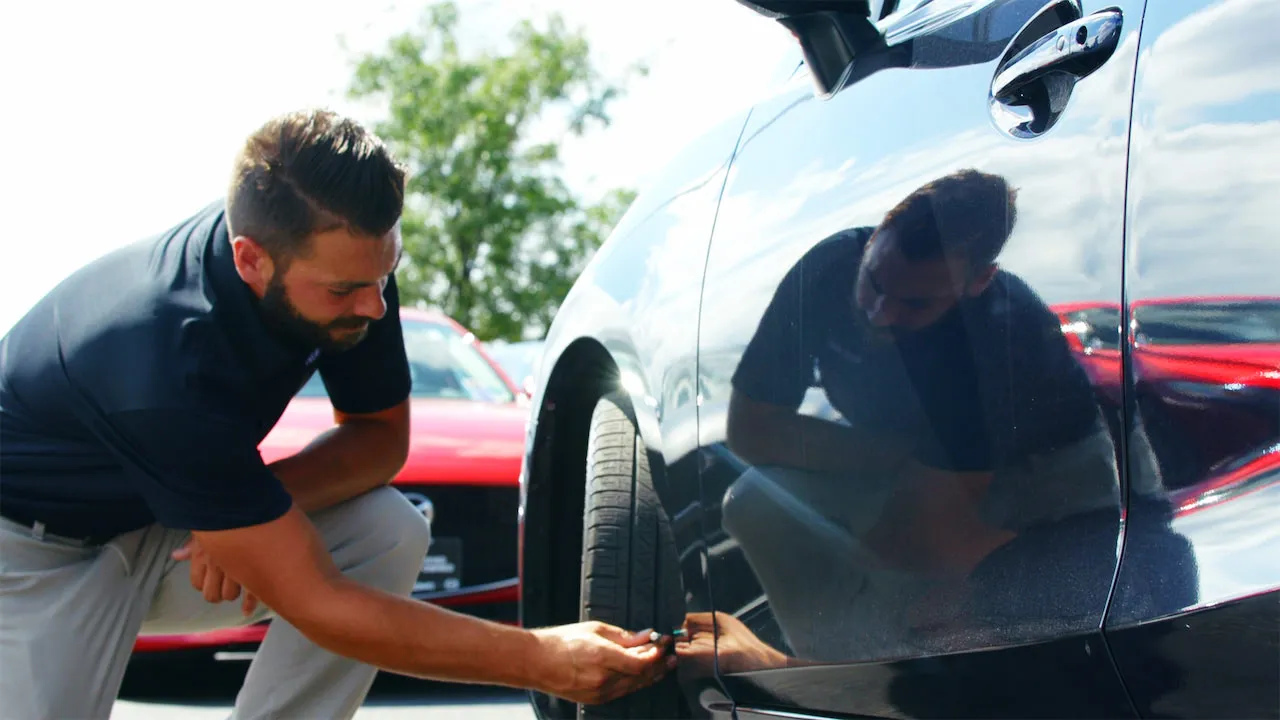dealer examining a car ready to sell