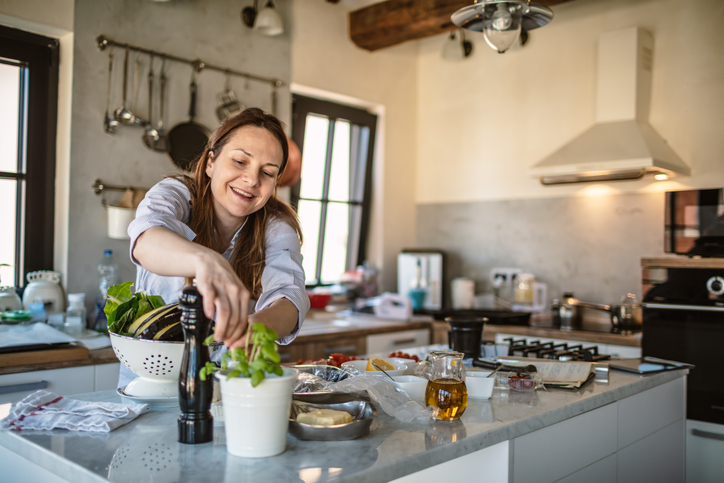 a young woman cooking mediterranean food for dinner, she prepare a fresh zucchini with tomato.