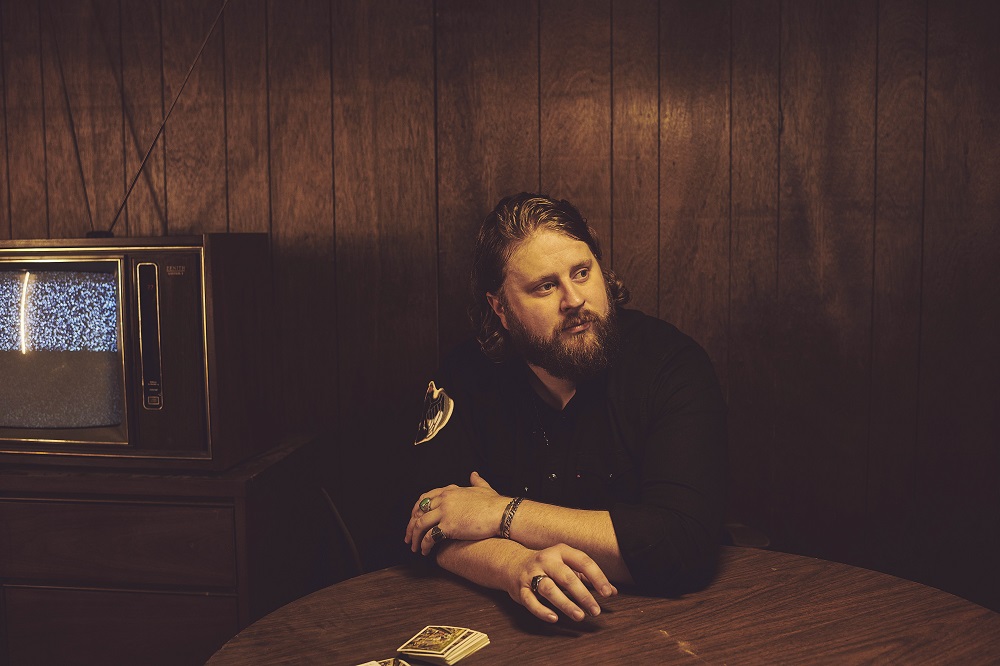 Nate Smith sits at a wooden table.
