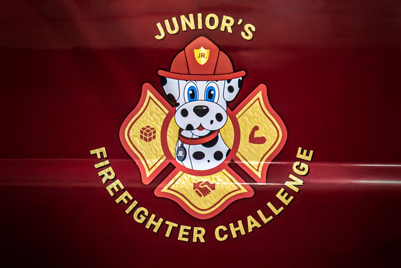 junior fire fighter logo with an illustrated dalmatian wearing a fire fighter hat