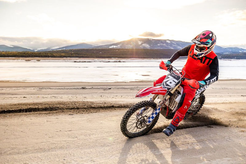 Motor cross cyclist riding along a sandy beach