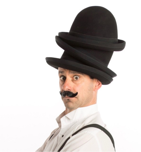 The Great Balanzo faces the camera wearing three bowler hats