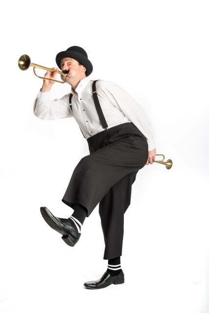 The Great Balanzo dances and plays two trumpets