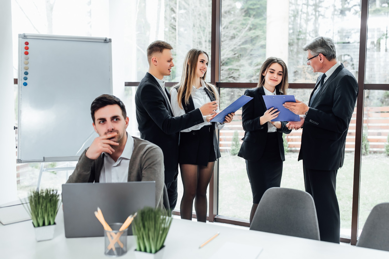 An employee sitting at the table thinking of how to ask senior leaders effective questions