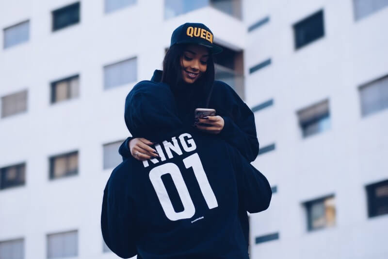 man carrying a woman wearing cap and jacket