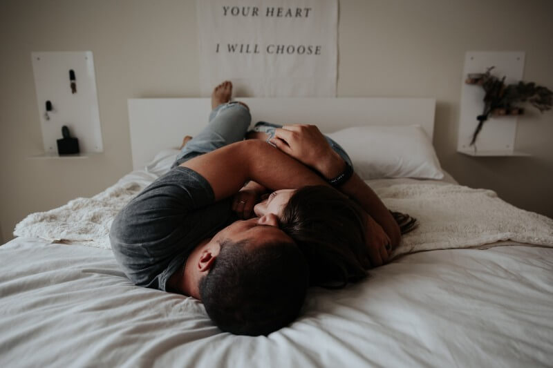 man and woman hugging in bed