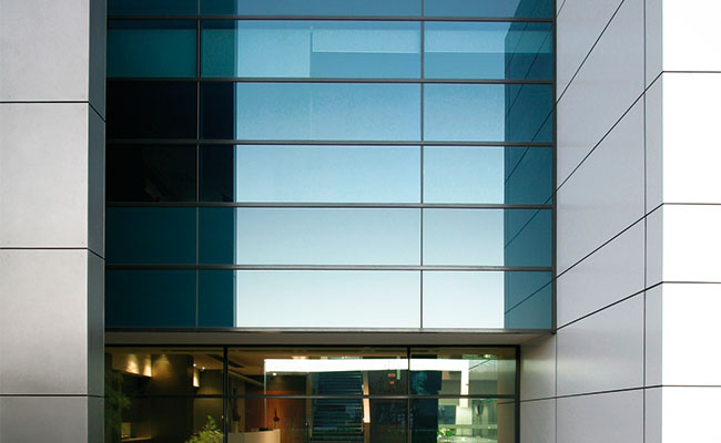 Dark blue tinted glass for key window in office building, providing privacy for workers.