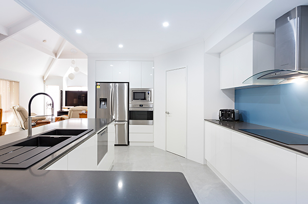 Kitchen bench with stools, blue splashback is visible in the background