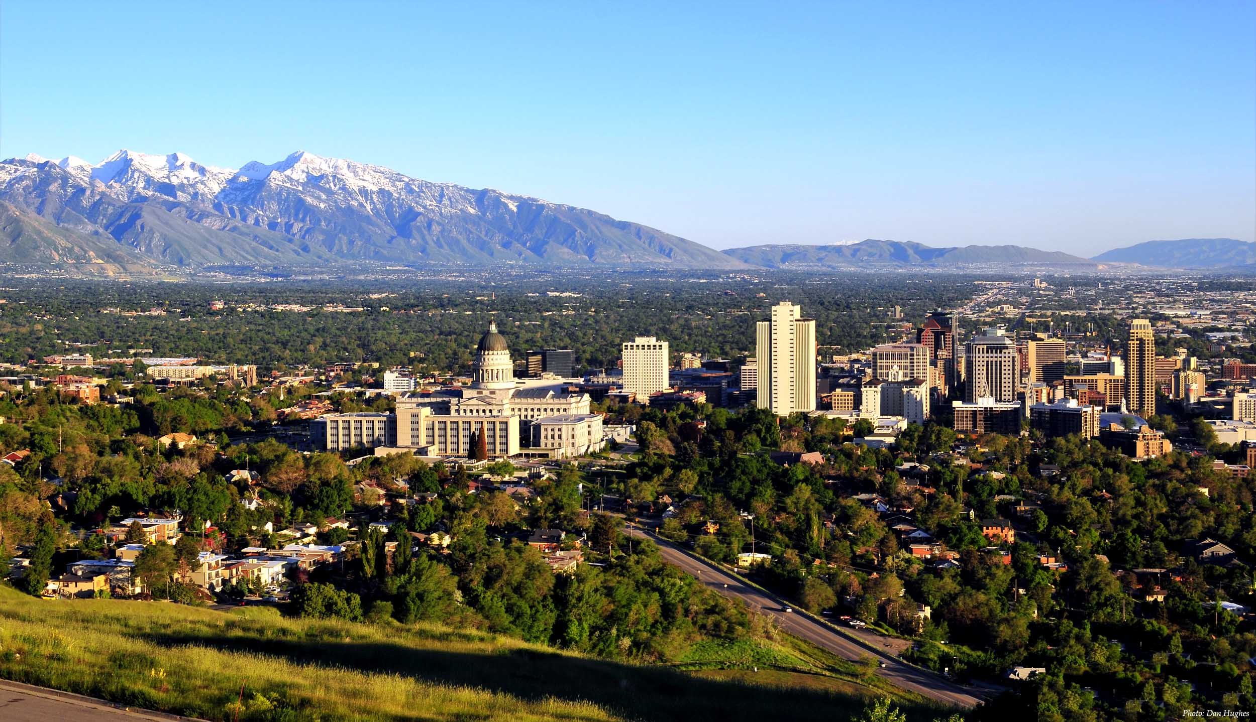 Wide shot of Cheyenne Wyoming skyline at dusk with mountains in the background.