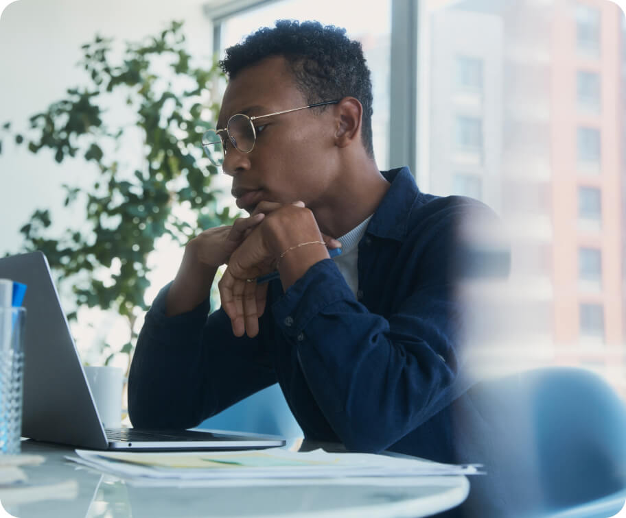 a man sitting in his desk looking at his laptop