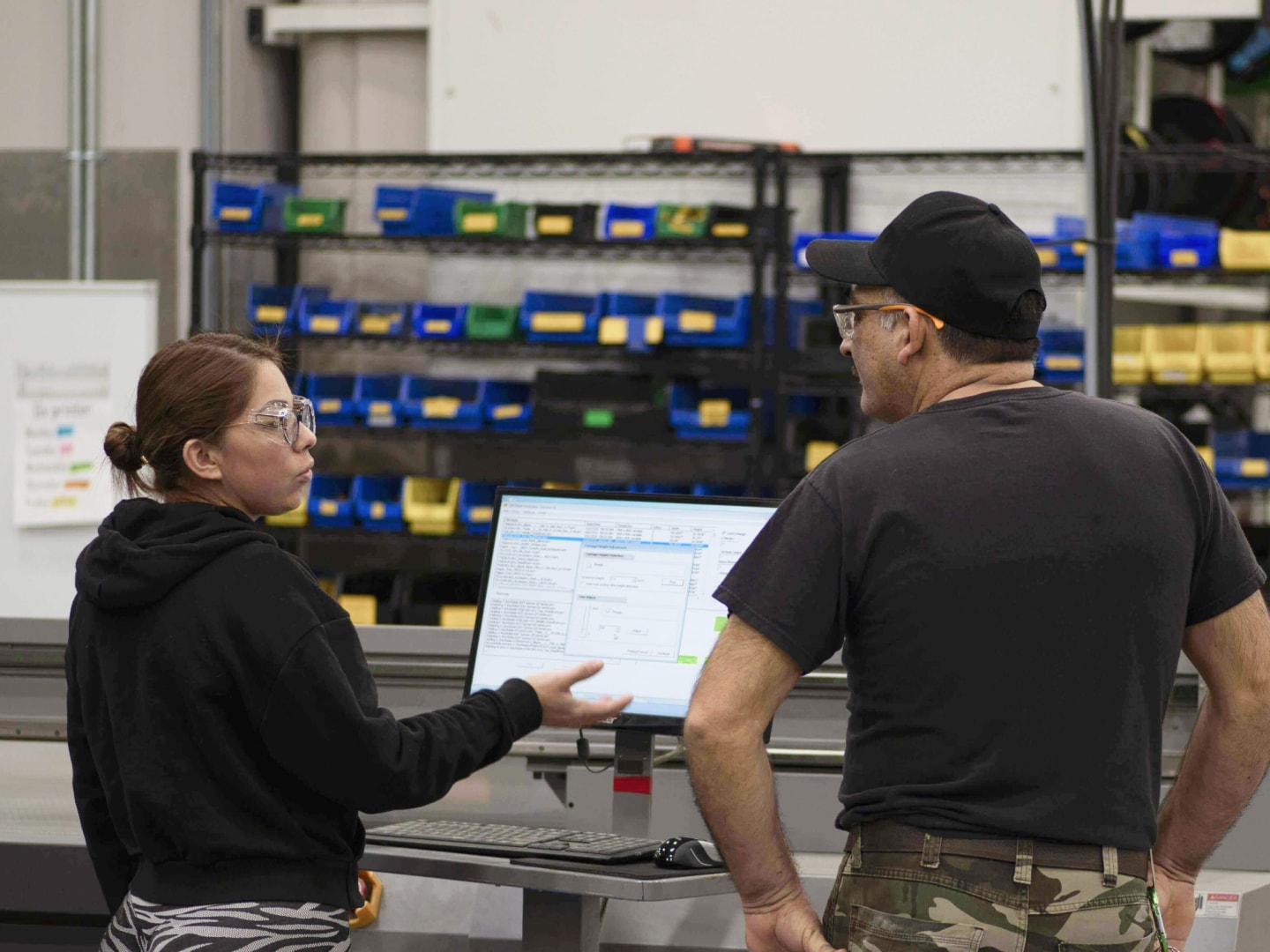 Coworkers talking in front of machinery