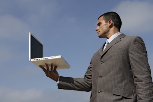 Man ponders the future of IT while holding laptop