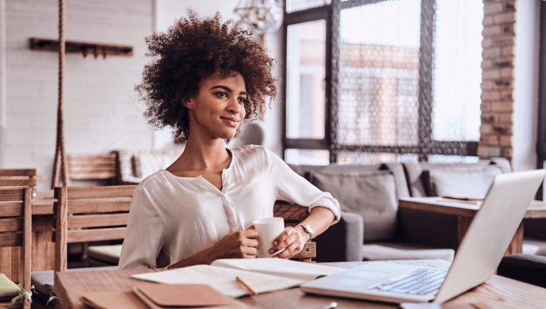 picture of a woman at a desk drinking coffee