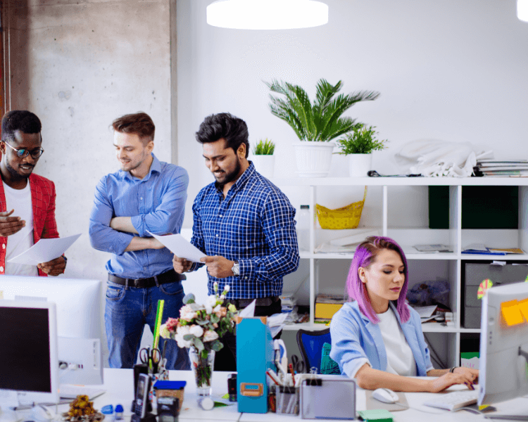 Four colleagues collaborating in an office space.