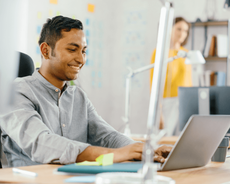 Man smiling at his laptop.