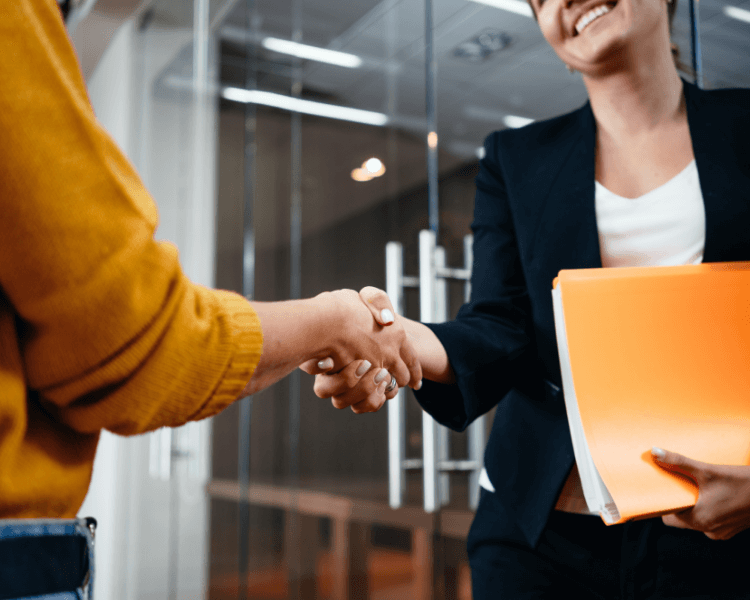 Two women shaking hands.