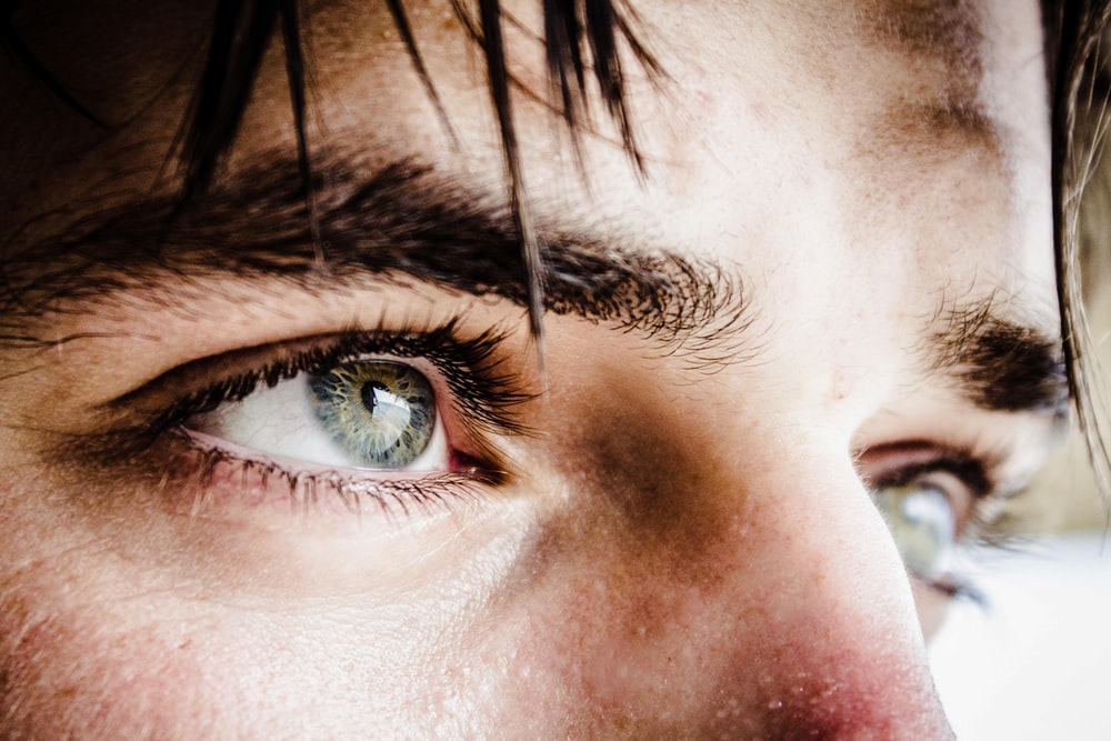 Close up of a mans green eyes.