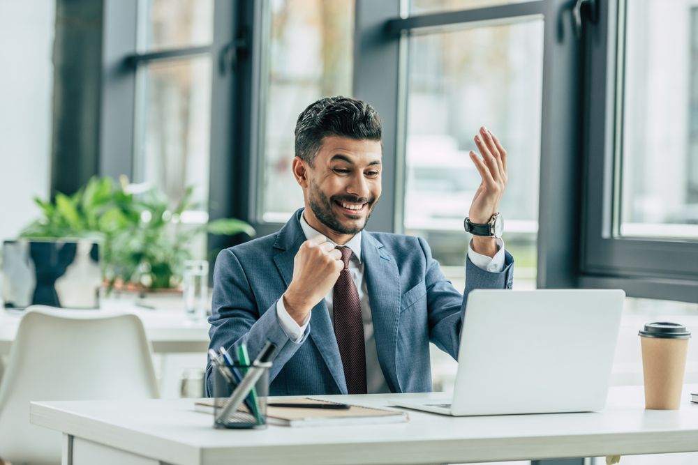 a man celebrating during a video call.