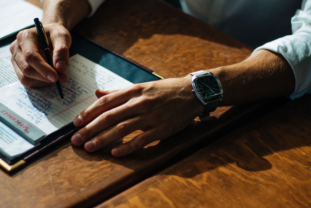Close up photo of a man going over a list on a notepad.