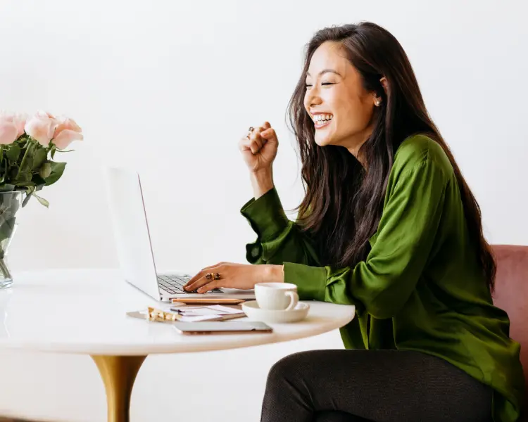 a woman at a laptop excited she found a ceo email address