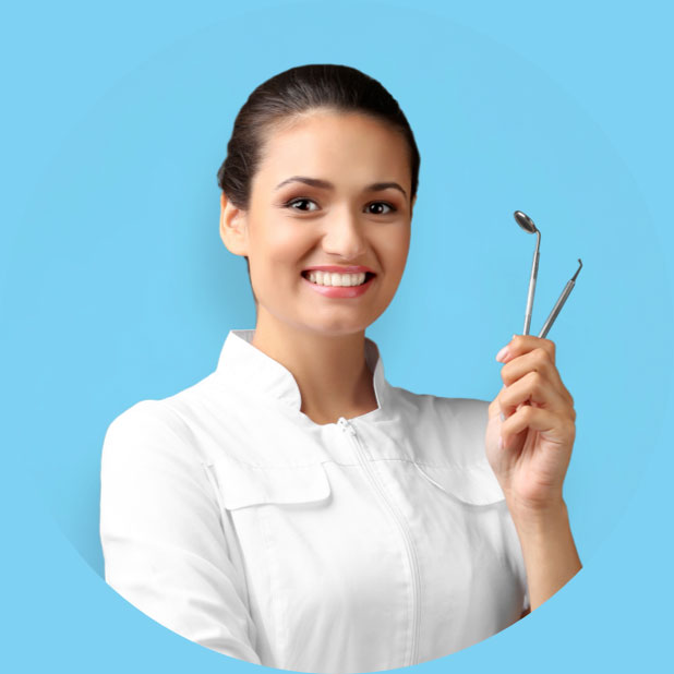 Dentist smiling while holding dental tools