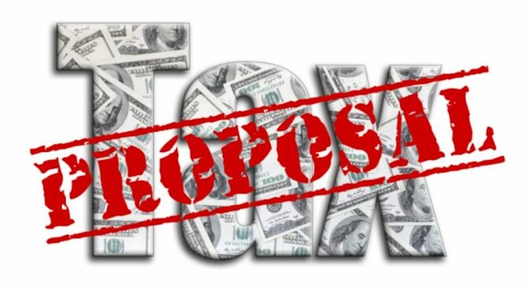 A red-letter stamp of proposal across the word tax, made out of dollar bills