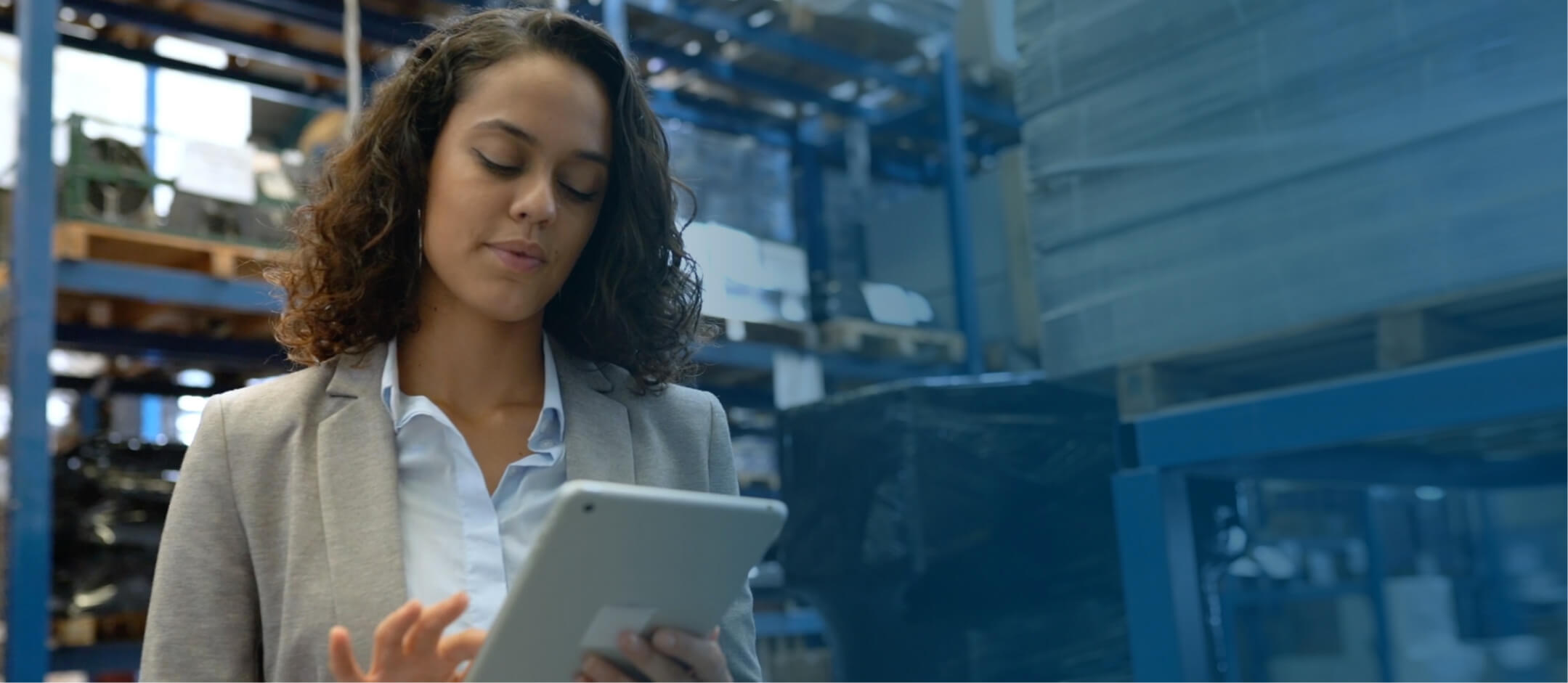 A woman in a warehouse using a tablet