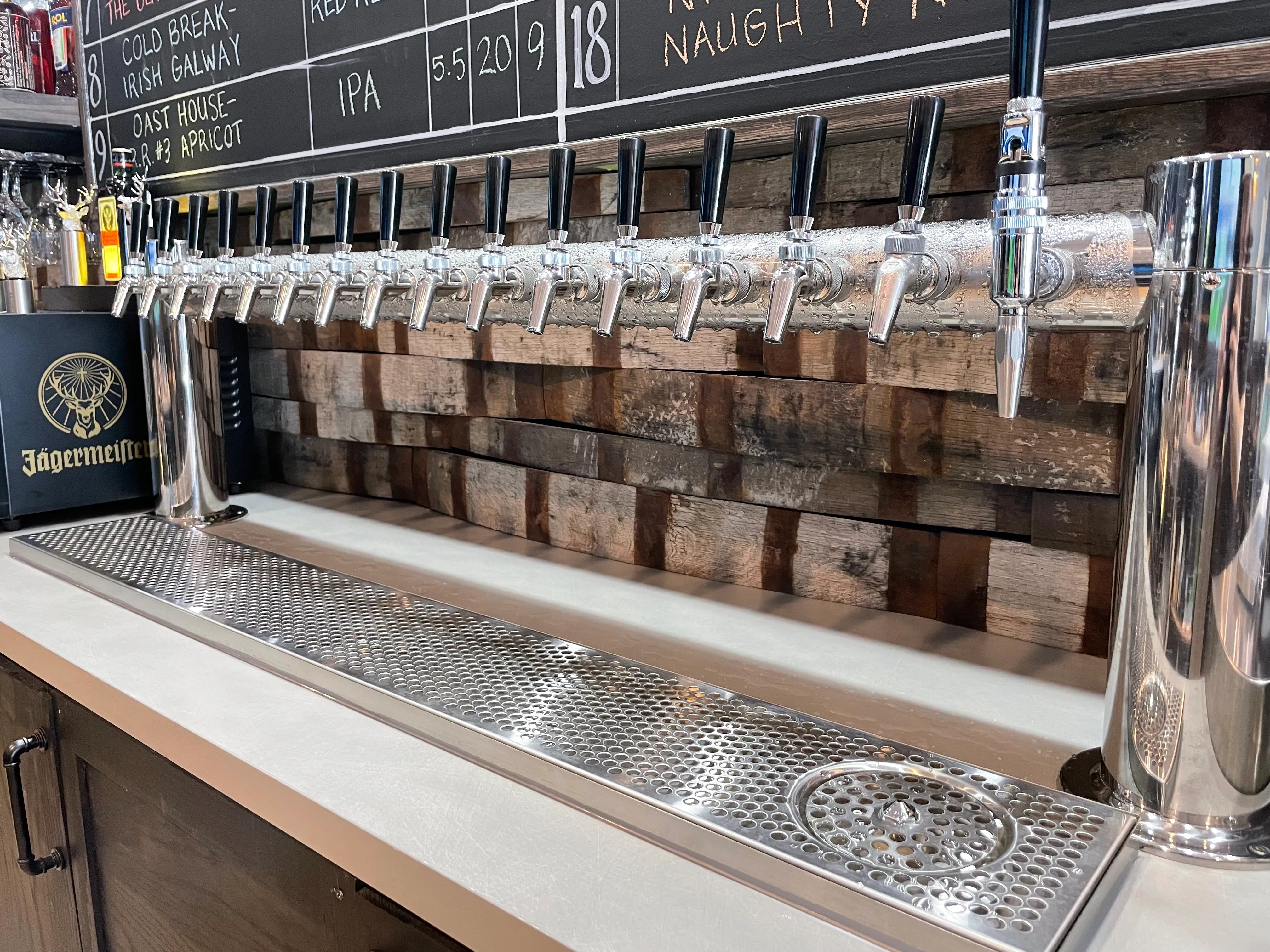 A stainless steel draught beer tower with 16 taps