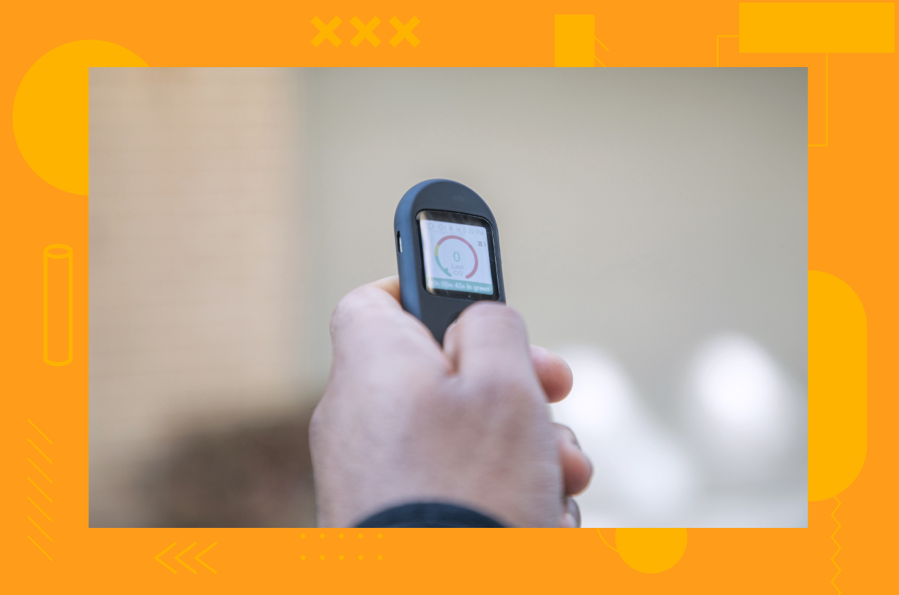 Person holding Pivot Breath Sensor with a zero reading on the screen