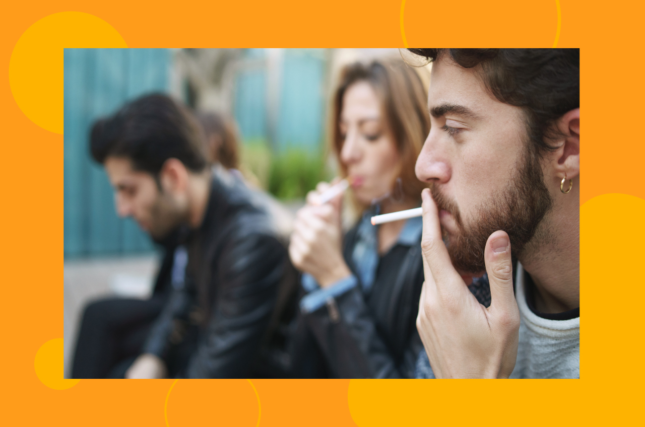 Group of people sitting outside smoking cigarettes