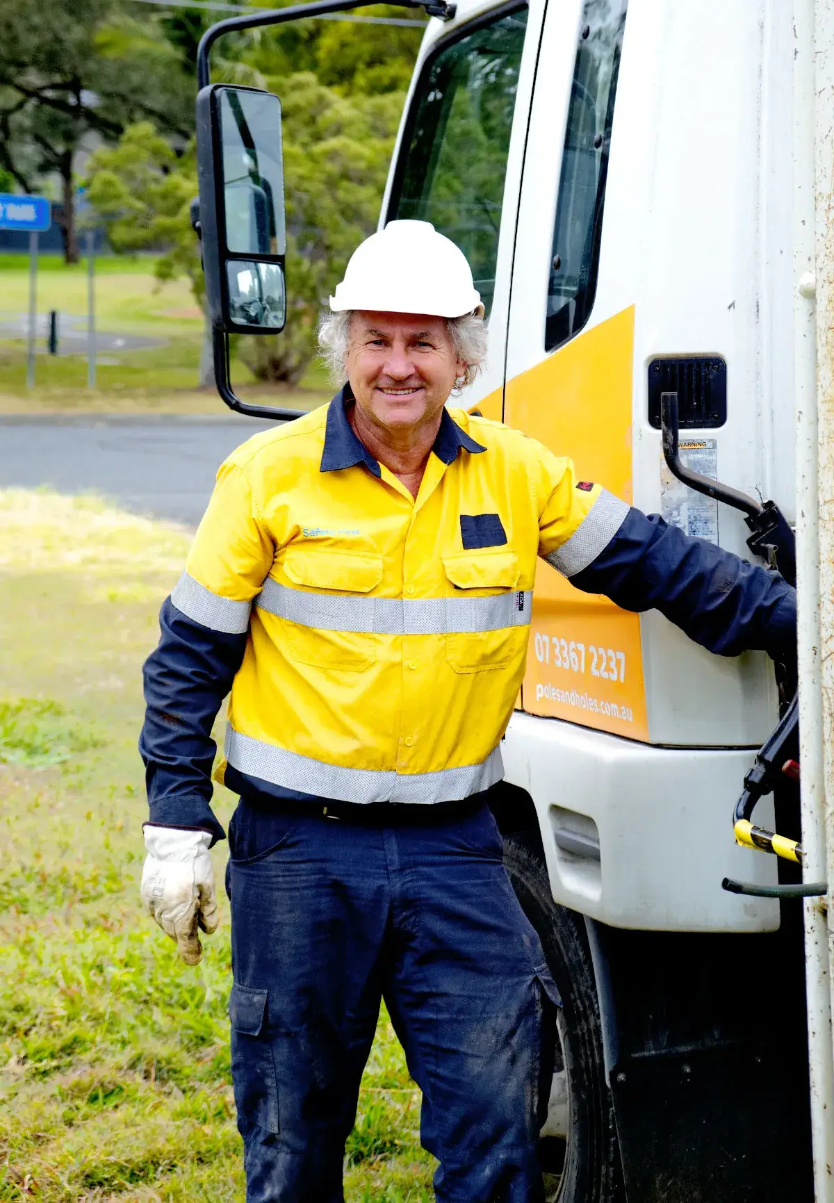 Poles and Holes employee Geof smiling in front of truck before he is about to install a Temporary Power Pole. 
