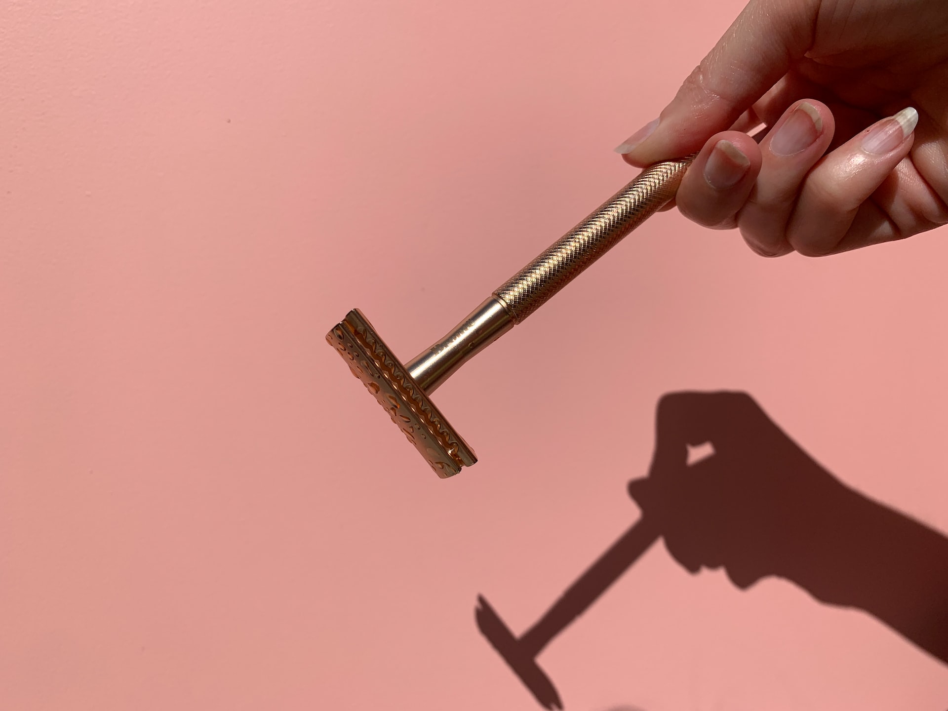 Person holding golden safety razor