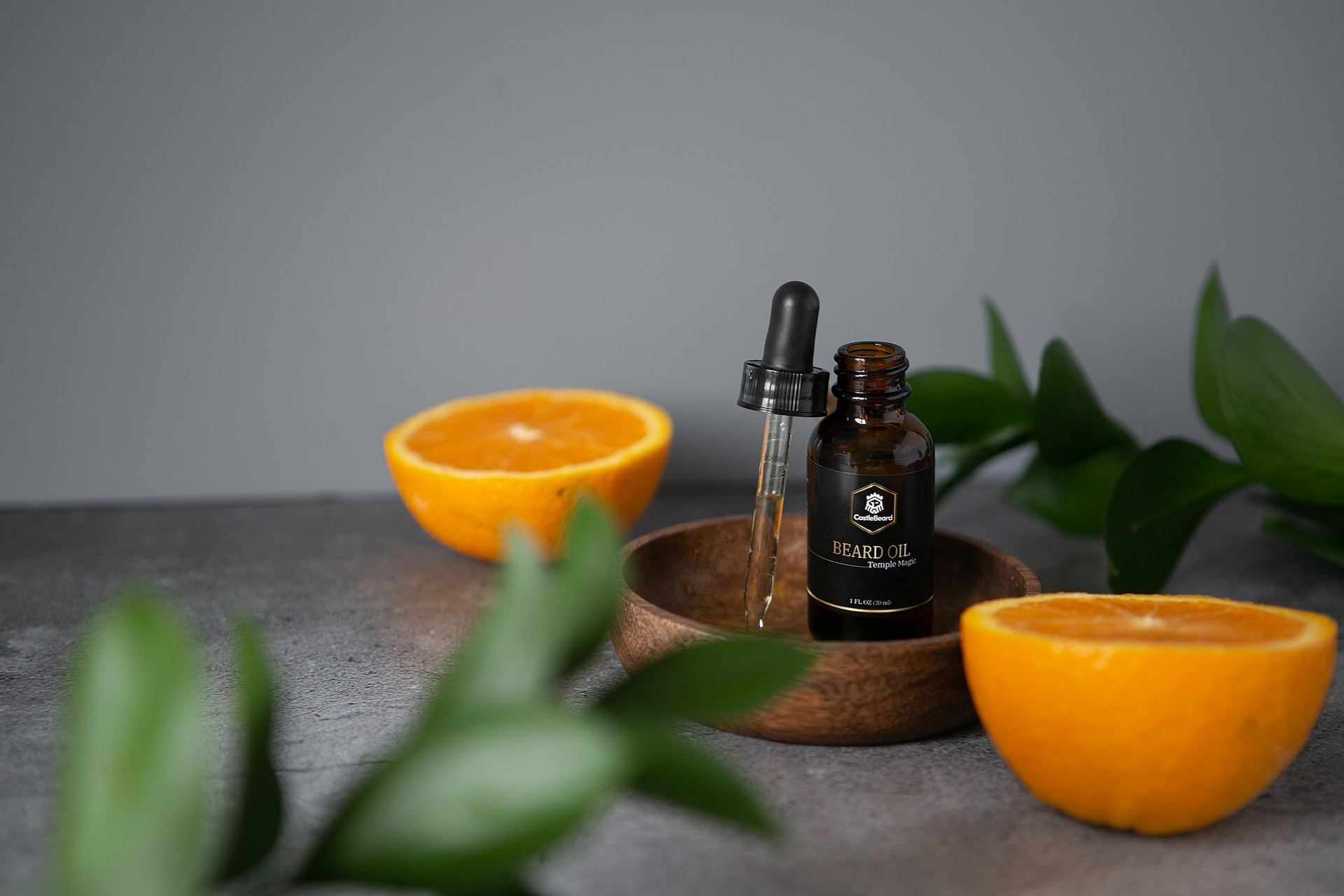 black-bottle-of-beard-oil-next-to-oranges